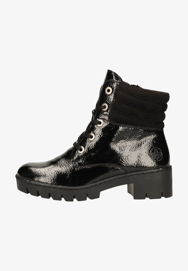 Bottines noires à la cheville avec une finition en cuir verni brillant, un revers en daim, des œillets blancs et une semelle crantée épaisse. Présentent un détail de logo sur le côté.