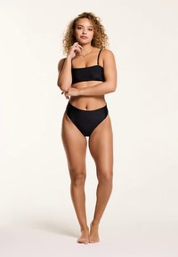 Black bikini set featuring a fitted bandeau top and high-waisted bottoms, smooth fabric, minimal hardware, and sleek design.