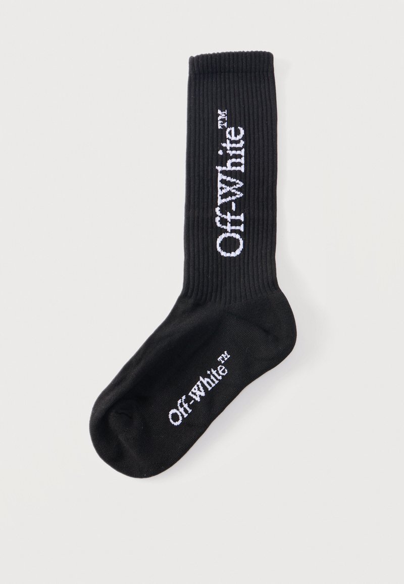 Chaussette montante noire côtelée avec le texte blanc "Off-White™" en vertical sur le mollet et en horizontal sous la plante du pied.