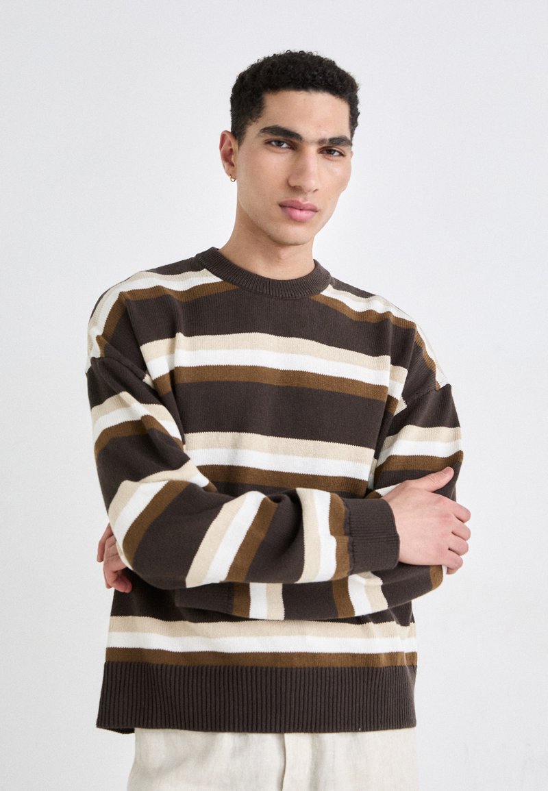 Brown and cream striped knit sweater with a ribbed crew neck and cuffs. The sweater features wide horizontal stripes in varying widths.