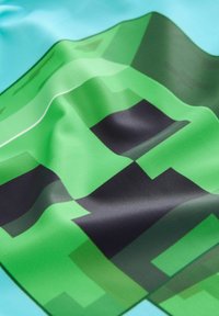 Tessuto verde con un design pixelato e accenti neri, su uno sfondo azzurro chiaro. Texture liscia con finitura lucida.