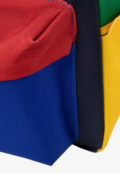 Sac de rangement multi-poches en tissu synthétique rouge, bleu, vert, noir et jaune. Avec des surfaces texturées et des bords cousus.