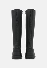 Stivali neri waterproof alti fino al ginocchio con finitura opaca, dotati di un pannello laterale testurizzato e logo in rilievo sul tallone. Chiusura con zip sul retro.