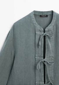 Szaro-zielona lniana kurtka z trzema wiązaniami na przodzie i okrągłym dekoltem, oznaczona marką Massimo Dutti.