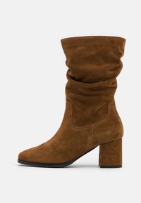 Brown suede mid-calf slouch boot with block heel and rounded toe, viewed from the side on a plain white background.