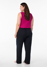 Magenta ribbad strumpa topp ja svarta vida byxor. Mjuk tyg med lös passform, sömlinsmidda midja och slät struktur. Inga märkbara mönster eller accenter.
