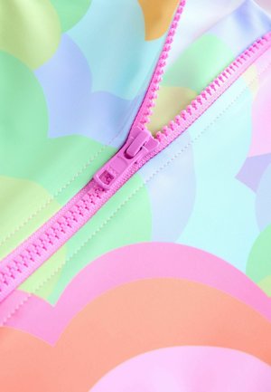 Material de îmbrăcăminte de baie colorat, cu un model pastelat ușor, format din forme suprapuse în nuanțe de verde, piersică și albastru. Un fermoar roz se află pe o latură.