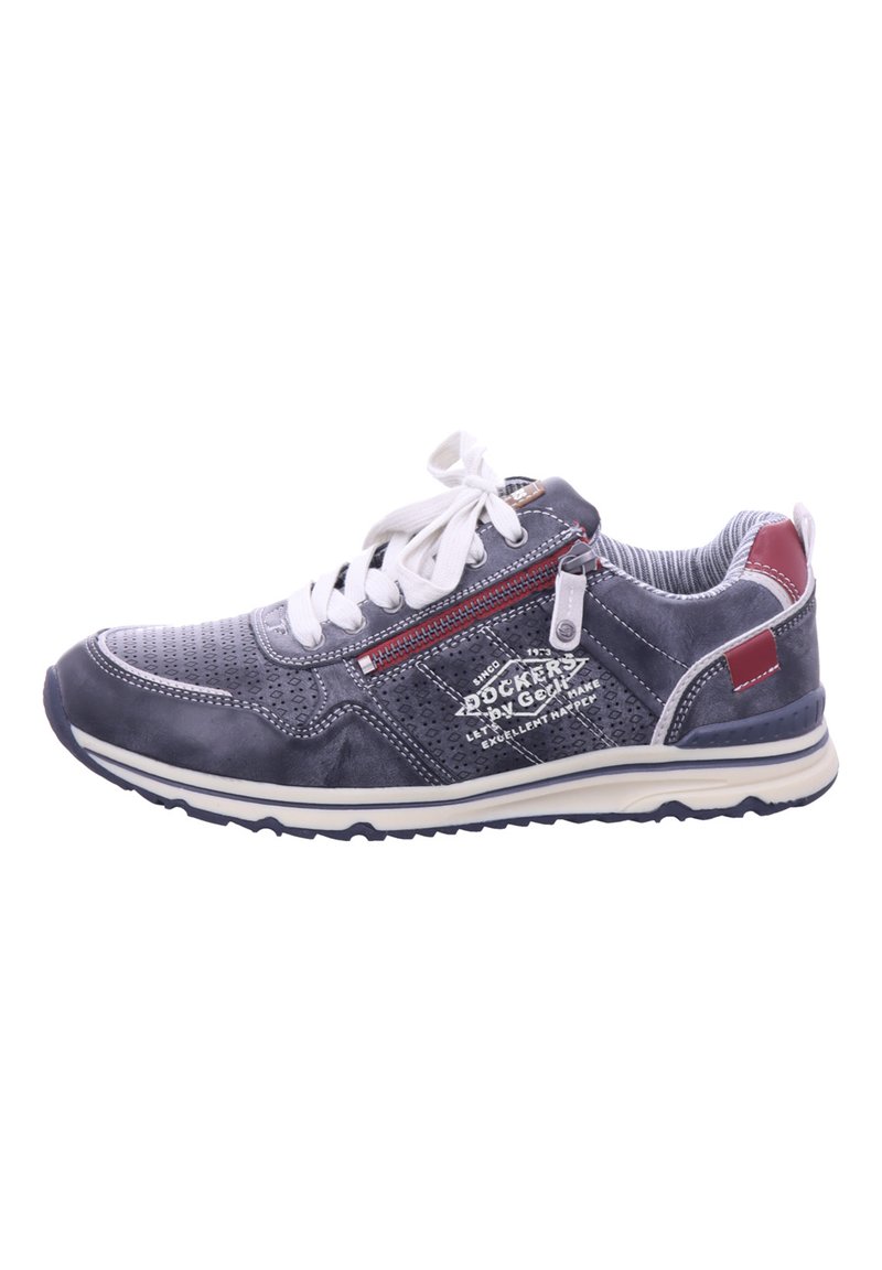 Scarpa sportiva grigia con lacci bianchi, texture perforata e un accento rosso. Presenta una cerniera laterale e una suola in gomma con battistrada a motivo.