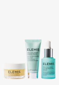 Trois produits de soin de la peau : un pot jaune de baume nettoyant, un tube vert de crème de jour et un flacon compte-gouttes turquoise de sérum.