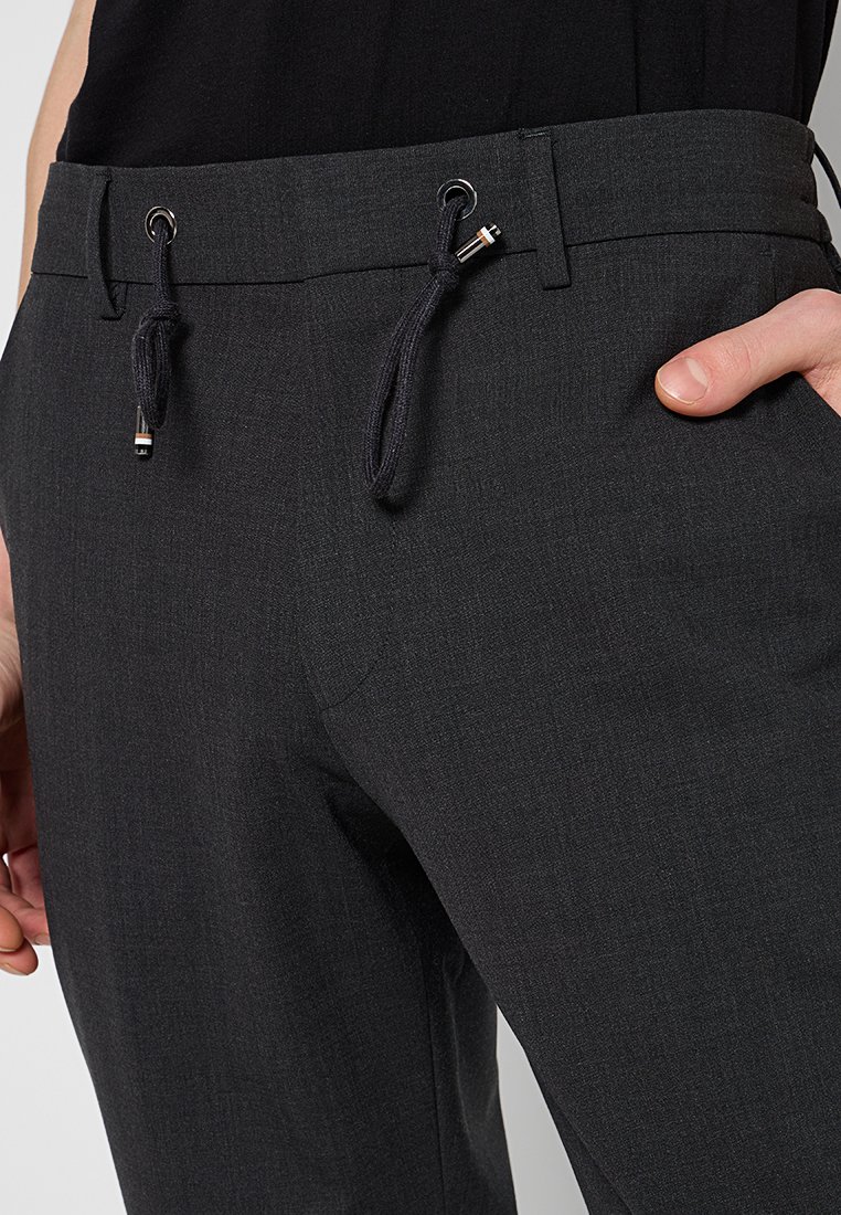 Graue, strukturierte Hosen mit einem elastischen Bund und verstellbaren Kordeln, metallischen Akzenten und einer taillierten Passform.