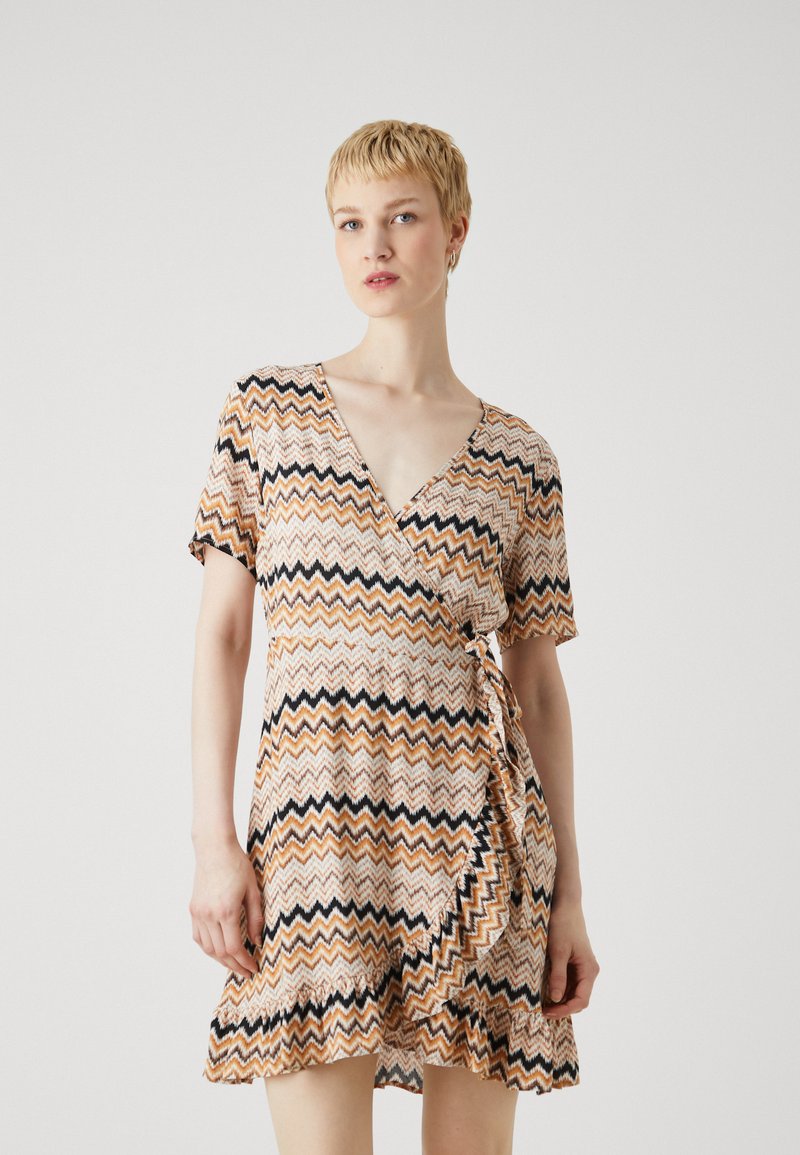 Φόρεμα με ζιγκ-ζαγκ μοτίβο σε πορτοκαλί, μαύρες και κρεμ αποχρώσεις. Βραχίονες κοντοί, v-λαιμόκοψη και λεπτομέρεια με φούσκες στο τελείωμα. Μαλακό ύφασμα.