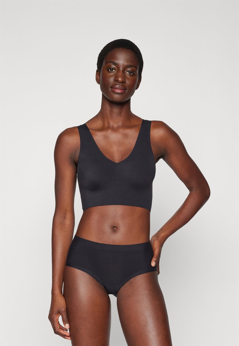 Black seamless bralette with a deep V-neck and wide straps, paired with matching high-waisted briefs. Smooth fabric texture.