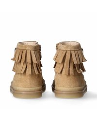 Stivaletti alla caviglia in suede beige con dettagli in frange sul retro, caratterizzati da una punta liscia e arrotondata e una suola leggera e flessibile. Chiusura con fibbia sul lato.