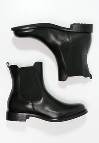 Black leather ankle boots with elastic panels, round toe, and low stacked heel. Smooth texture and minimalistic design.