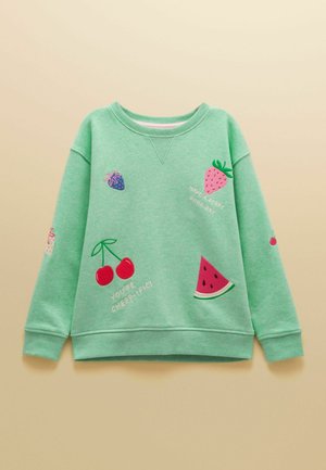 Vihreä collegepaita, johon on kirjailtu hedelmiä kuten kirsikoita, mansikkaa, vesimelonia sekä positiivisia lauseita kuten "Olet kirsikkan mainio!" ja "Ihanaa marjapäivää."