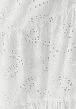 Hvidt broderet stof med blomster- og bladmotiver, med udskårne detaljer og en rynket tekstur i bunden.