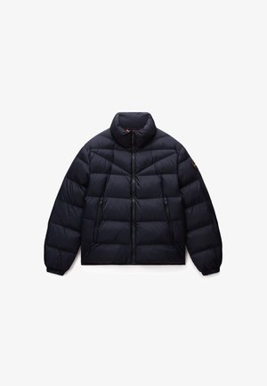 Jūras zila puffer jaka ar augsto apkakli, horizontālu quilted rakstu, divām ar rāvējslēdzēju aizveramām sānu kabatām un elastīgām aprocēm. Piedāvā priekšējo rāvējslēdzēja aizdari.