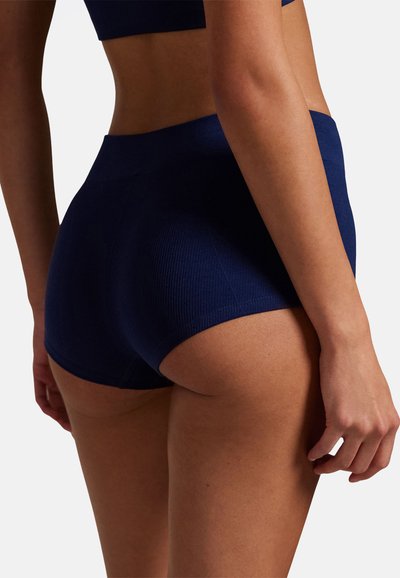 Shorts blu navy a coste con una fascia in vita senza cuciture, caratterizzati da una vestibilità aderente e una texture sottile. Ideali per il comfort e l'uso quotidiano.
