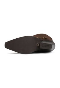 Brown suede ankle boot with a pointed toe, flat black rubber sole, and side gold accents. Features textured outsole for grip.