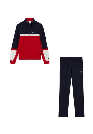 Chaqueta deportiva azul marino y roja con rayas blancas combinada con pantalones deportivos azul marino sólidos, ambos con un pequeño logo en el lado izquierdo.