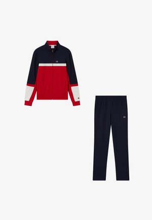 Chaqueta deportiva azul marino y roja con rayas blancas combinada con pantalones deportivos azul marino sólidos, ambos con un pequeño logo en el lado izquierdo.