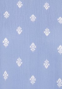 Hellblauem Stoff mit einer strukturierten Oberfläche, der ein weißes Blumenmuster aufweist, das in einem wiederholten Design angeordnet ist.