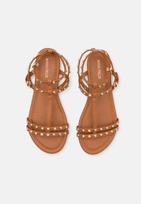 Brune flate sandaler med flere stropper, med gullnitter. Glatt tekstur med et enkelt design og ankelhefte.