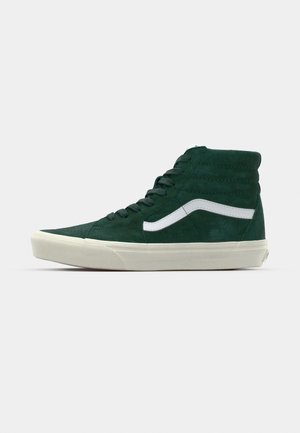 Høje sneakers i mørkegrøn ruskind med hvid sidestribe, polstret krave og tekstureret detaljering, der har en cremet gummisål.