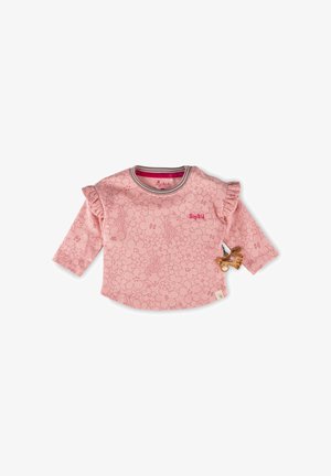 Helles rosa Langarmshirt mit floralem Muster, Rüschenakzenten an den Schultern und einem dekorativen Holzanhänger in Tierform an der Seite.