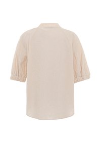 Blouse crème à manches courtes avec une subtile texture florale et des poignets élastiqués froncés, vue de dos sur fond blanc.