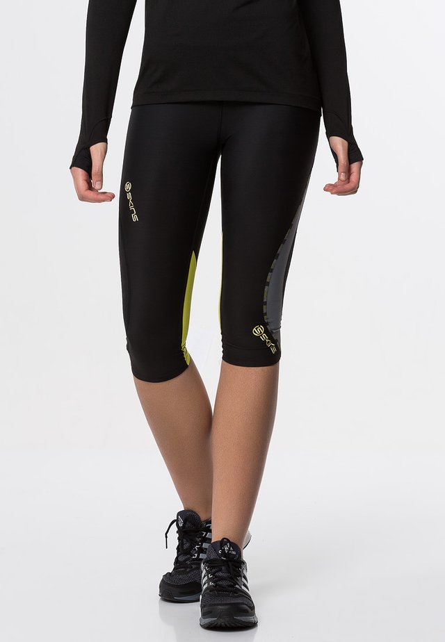 DNAMIC - Pantalón 3/4 de deporte - black/limoncello