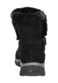 Botín de ante negro con puño de piel sintética, lengüeta en el talón y suela de goma. Cuenta con una correa de Velcro para un cierre seguro.