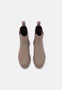 Brown ankle boots with smooth, matte textured surface, pull tabs, and chunky soles, featuring a subtle color variation on the sides.