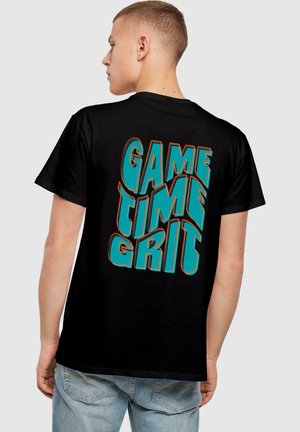 Sort bomulds t-shirt med en iøjnefaldende, farverig grafik på ryggen med teksten "GAME TIME GRIT" i turkis og orange.