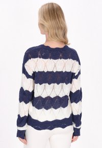 Pulover tricotat cu un model geometric în albastru marin și alb, cu o croială lejeră, guler rotund și material texturat, semi-transparent.