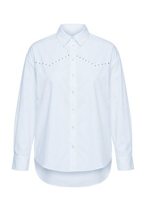 Camicia bianca a maniche lunghe con bottoni, colletto appuntito, orlo curvo e linee diagonali di piccoli borchietti metallici sul petto.