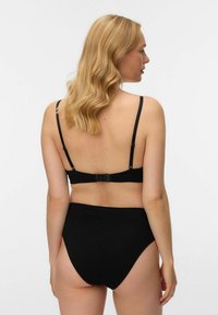 Svart BH med justerbare stropper og hekte lukking, kombinert med svart høytlivstruse. Mykt elastisk materiale, sømløs design.