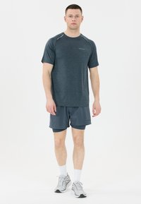 Donkergrijs sportshirt met korte mouwen en reflecterende accenten, gecombineerd met bijpassende shorts. De outfit heeft een lichtgewicht, ademend materiaal.