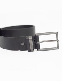 Cinturón de cuero negro con hebilla de plata mate, que presenta un diseño plano y costuras visibles, junto con un detalle de broche metálico.