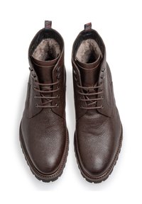 Botas de tobillo de cuero marrón con un acabado texturizado, punta redonda y diseño con cordones. Forro de piel suave y tiradores con patrón en el talón.