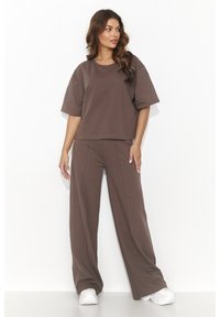 Brązowy zestaw dopasowany składający się z luźnej bluzki z krótkim rękawem i spodni o szerokich nogawkach, wykonany z miękkiego materiału, o czystej sylwetce i minimalnych detalach.