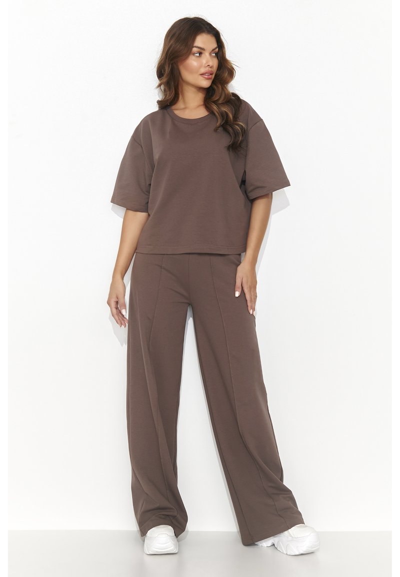 Brązowy zestaw dopasowany składający się z luźnej bluzki z krótkim rękawem i spodni o szerokich nogawkach, wykonany z miękkiego materiału, o czystej sylwetce i minimalnych detalach.