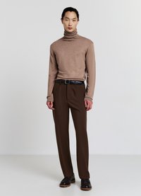 Brauner Rollkragenpullover, kombiniert mit maßgeschneiderten braunen Hosen. Hat eine glatte Textur, eine taillierte Passform und einen schwarzen Gürtel mit silberner Schnalle.