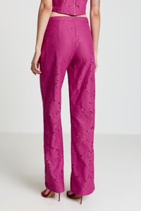 Pantalon en dentelle fuchsia à coupe ample, avec un motif floral et des détails ajourés. Texture lisse et jambes larges qui mettent en valeur le design.