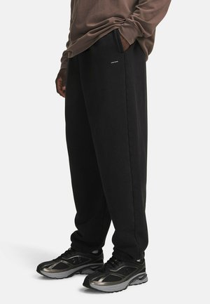 Under Armour, ICON HEAVYWEIGHT FLEECE WASHED - Trainingsbroek - ultimate black