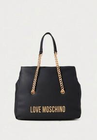 Černá kabelka ze syntetické kůže s rukojeťmi z pozlaceného řetězu, na přední straně se zlatým nápisem „LOVE MOSCHINO“. Hladká textura, velký tvar.