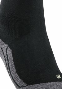 Calzino nero caratterizzato da un design senza cuciture, superficie testurizzata, tallone rinforzato e accento grigio lungo la base. Piccolo logo vicino alla caviglia.