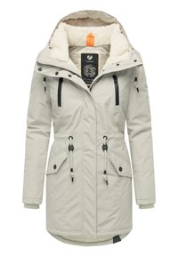 Jasno-beżowy wodoodporny parka z kapturem, z futrzanym podbiciem, dwoma przednimi kieszeniami, ściągaczem w talii oraz czarnymi zamkami i detalami z metalu.