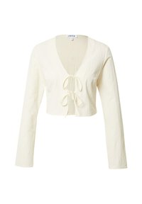 Haut ajusté à manches longues en tissu crème. Col en V avec détail noué à l'avant. Matière douce et texturée. Design simple.