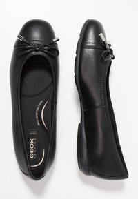 Svarta läderballerinor med rund tå, rosettaccent och silverdetaljer. Har en texturerad innersula och flexibel gummisula.